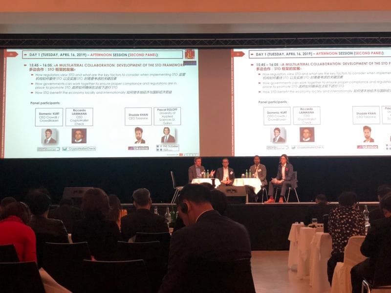 Security token offering panel in Davos, with Riccardo Lamanna listed on the presentation screens